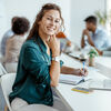 Female Employee Smiling in the Office, With Her Colleagues in Background. Shallow Focus